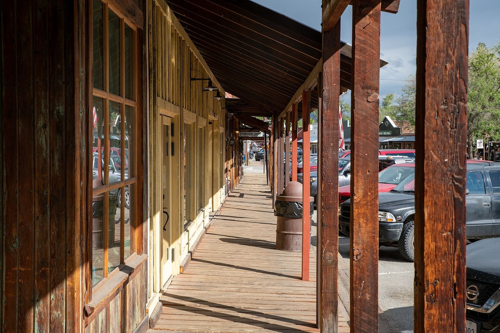 Covered wooden boardwalk with rustic posts along storefronts in Winthrop